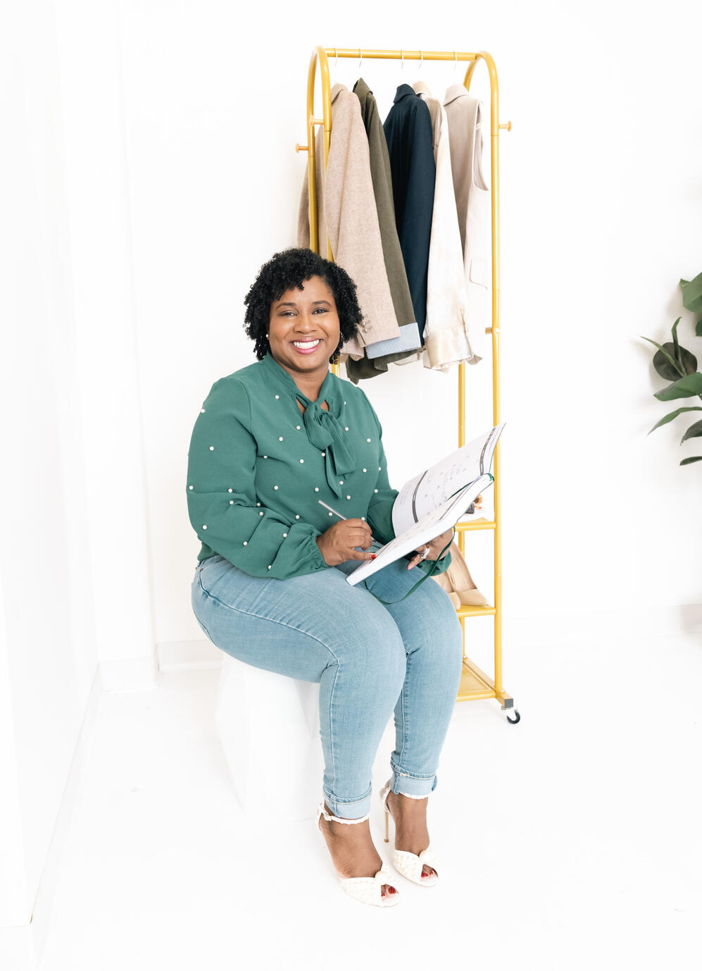 bria-johnson-casual-brand-portrait-green-top.jpg Bria Johnson seated in a green top and jeans, smiling during a brand portrait session.